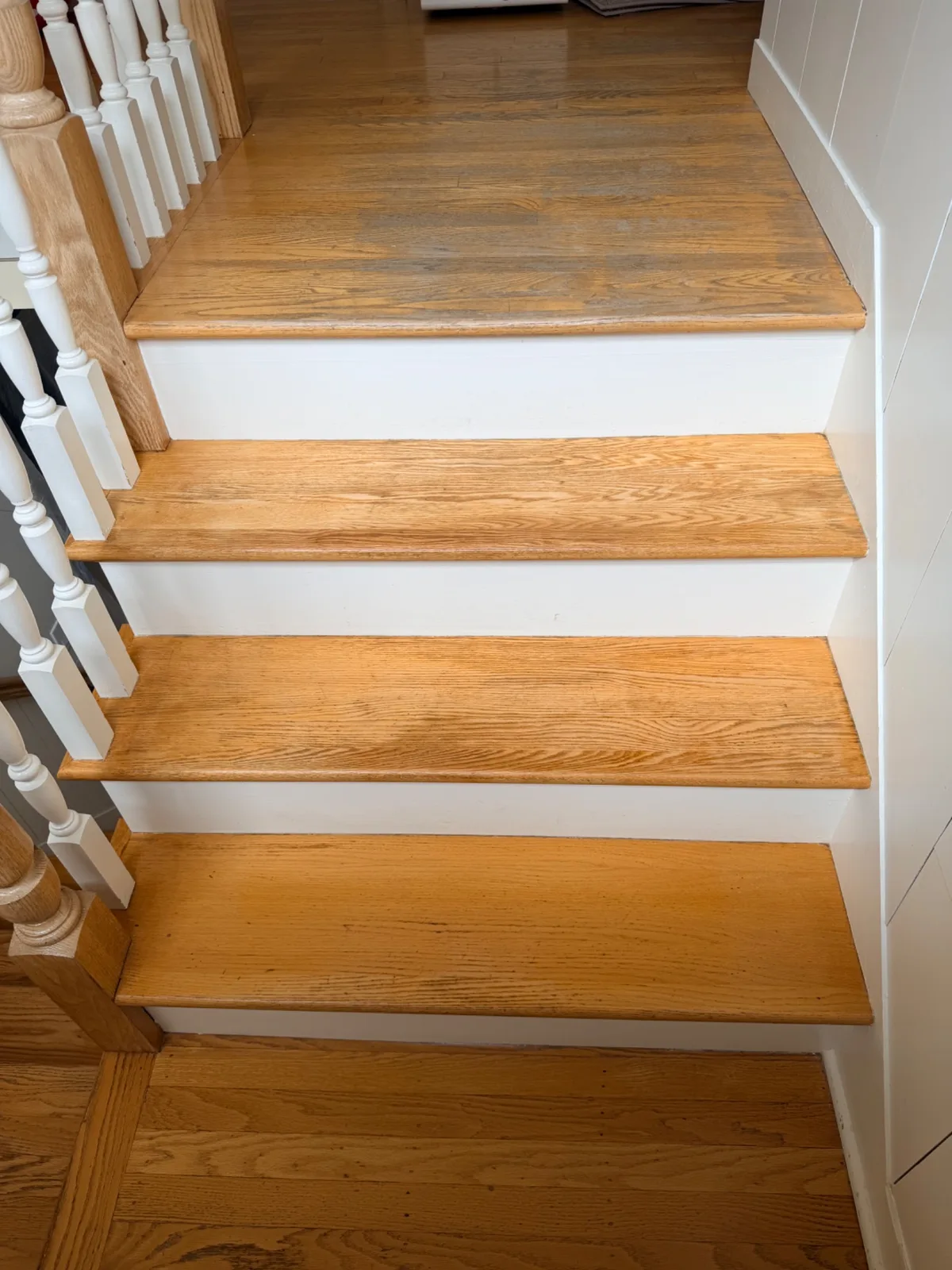 Refinished wooden stairs with natural wood treads and white risers in Trumbull.