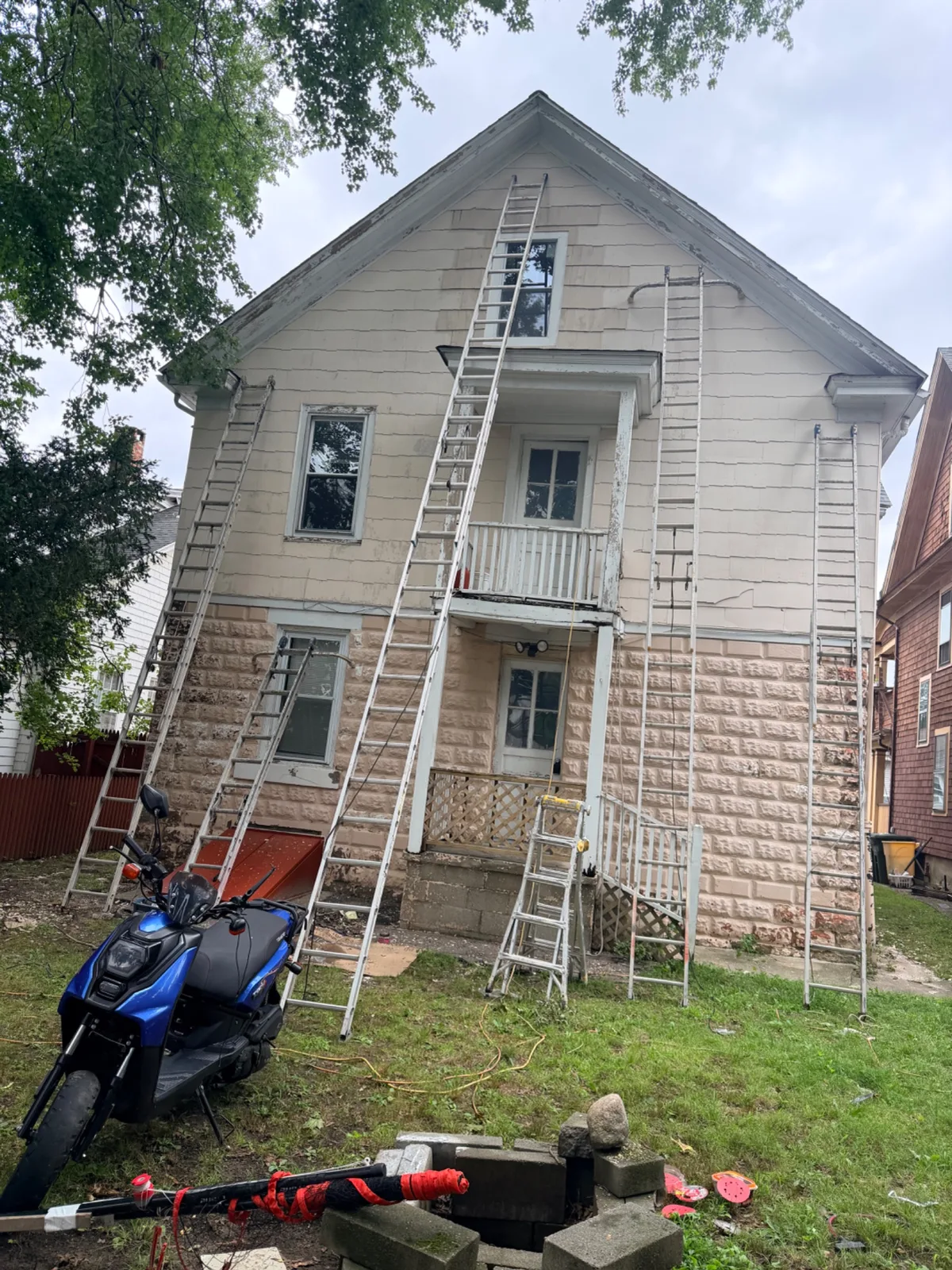 Ladders leaning against a house in Bridgeport during exterior painting preparation.