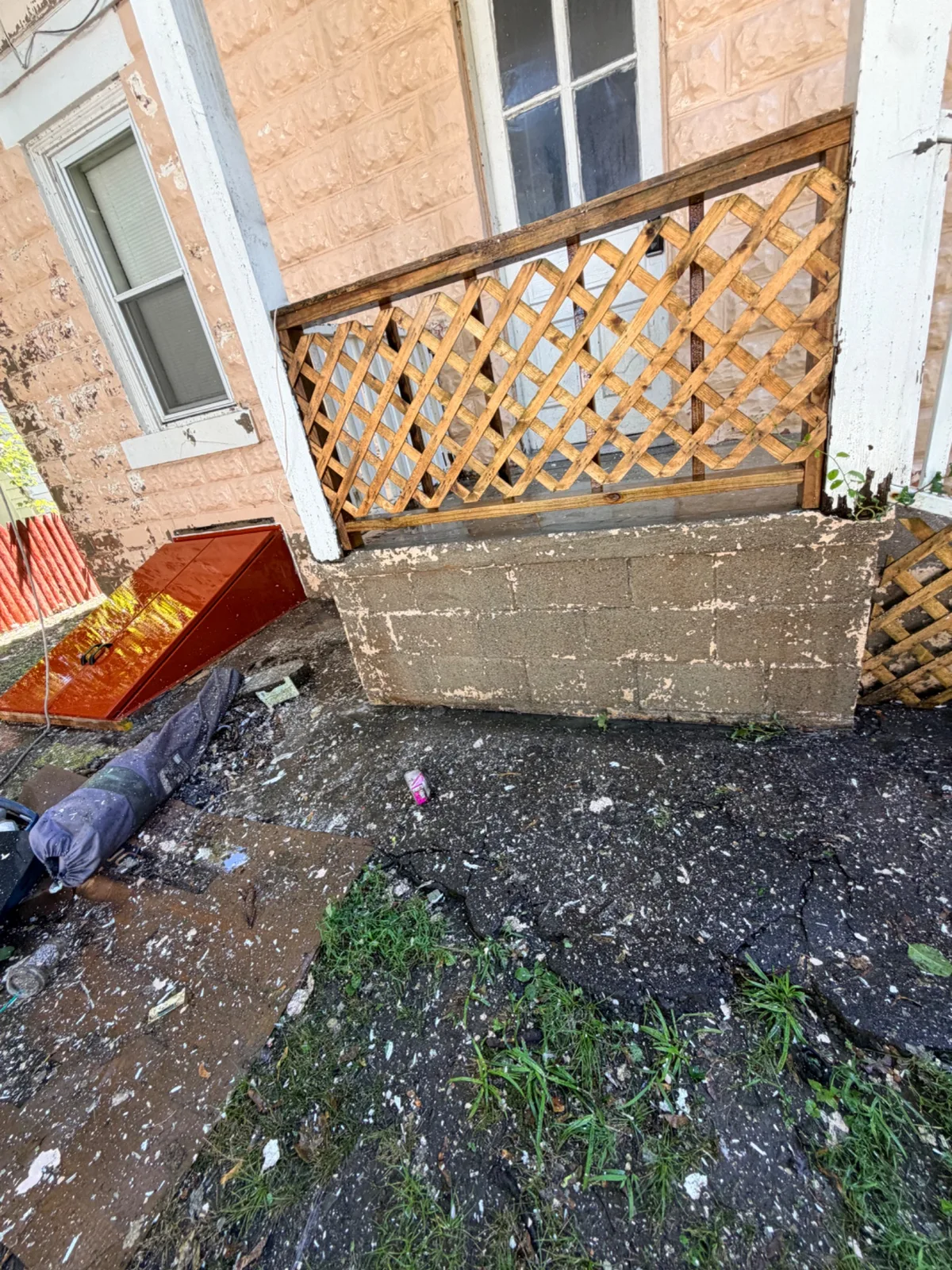 Exterior wall, porch, and cellar door at a home in Bridgeport during surface preparation for painting.